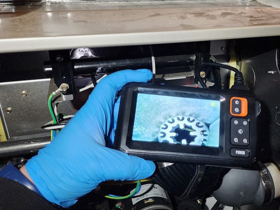 Technician inspecting a furnace inducer with an inspection camera